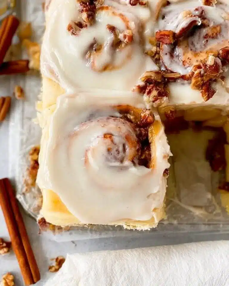 Freshly baked apple pecan cinnamon rolls topped with icing