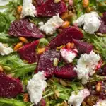 Colorful beet salad with fresh greens and nuts served in a bowl
