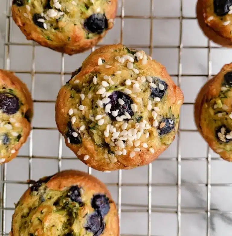 Freshly baked blueberry zucchini muffins on a cooling rack