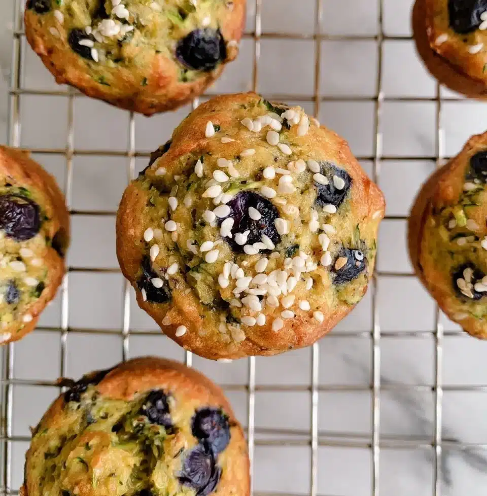 Freshly baked blueberry zucchini muffins on a cooling rack