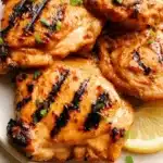 Deliciously cooked chicken thighs on a plate with herbs and spices