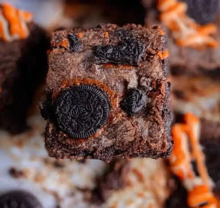Decadent Oreo Brownies topped with crushed Oreos and chocolate drizzle