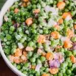 Fresh and colorful pea salad with vegetables and dressing.