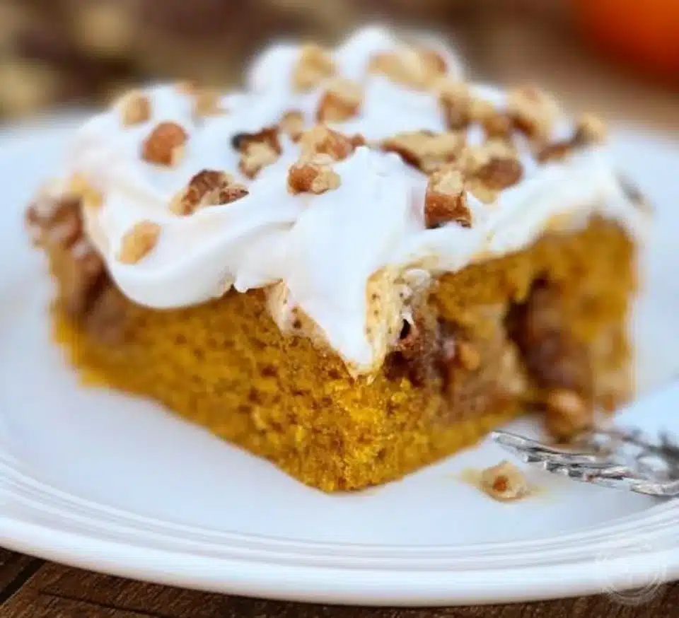 Delicious homemade Pumpkin Poke Cake topped with creamy frosting, ideal for fall desserts.