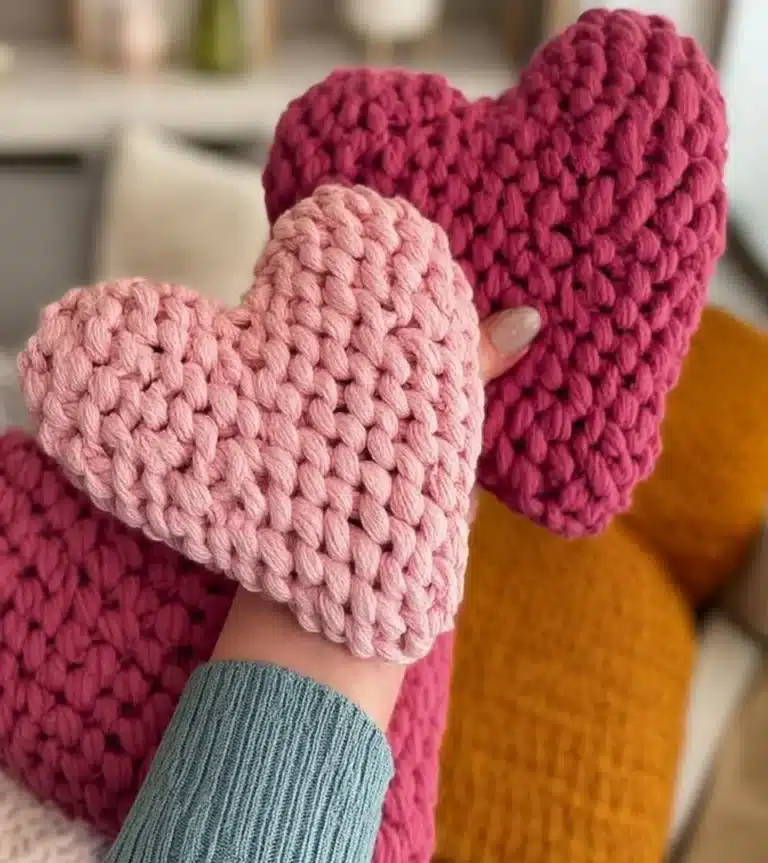 Handmade amigurumi hearts in various colors displayed creatively.